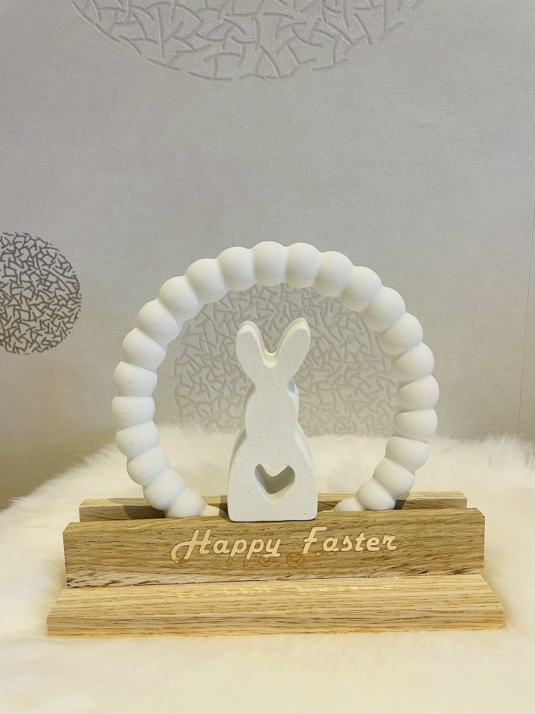 Osterhase mit Kranz auf beschrifteter Holz-Grundplatte